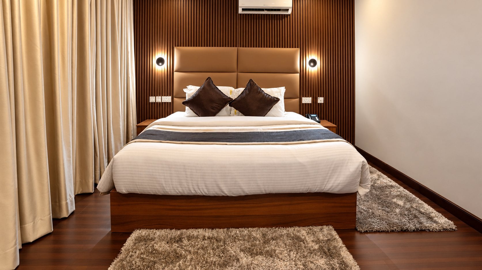 Palette Room: a king bed against warm timber wall panelling